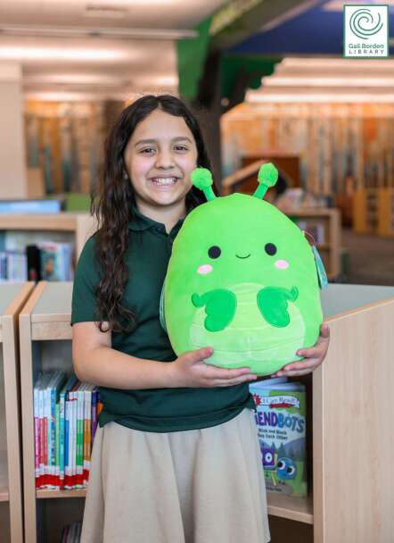 Image of a girl holding a summer reading prize